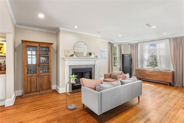 6035 Louis Xiv St, New Orleans, LA 70124 - living area featuring a tiled fireplace, light wood-style flooring, ornamental molding, recessed lighting, and baseboards