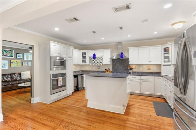 6035 Louis Xiv St, New Orleans, LA 70124 - kitchen with appliances with stainless steel finishes, wall chimney range hood, crown molding, white cabinets, and recessed lighting