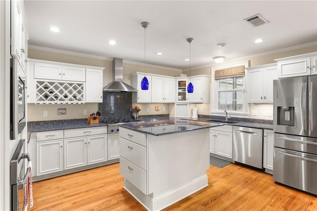 6035 Louis Xiv St, New Orleans, LA 70124 - kitchen with appliances with stainless steel finishes, wall chimney range hood, a sink, crown molding, and white cabinets