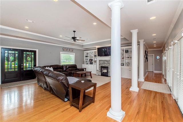 42251 Jefferson Dr, Hammond, LA 70403 - living area featuring ornate columns, light wood-style flooring, a ceiling fan, ornamental molding, and a stone fireplace