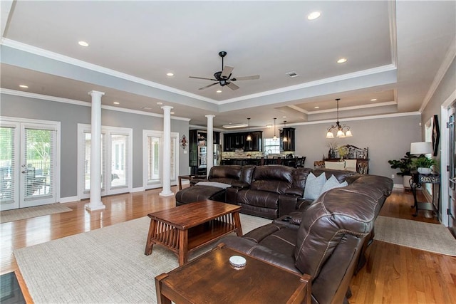 42251 Jefferson Dr, Hammond, LA 70403 - living area with decorative columns, a raised ceiling, a ceiling fan, light wood-type flooring, and baseboards