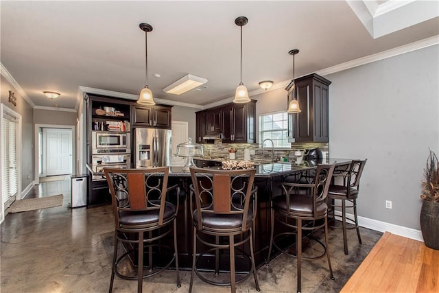 42251 Jefferson Dr, Hammond, LA 70403 - kitchen featuring stainless steel appliances, dark brown cabinetry, ornamental molding, a peninsula, and decorative backsplash