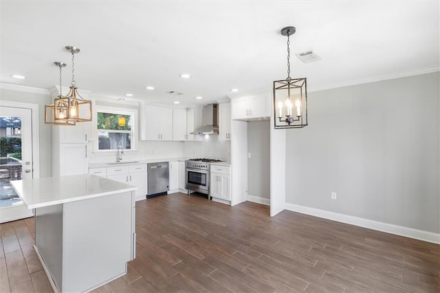 2308 Taft Park, Metairie, LA 70001 - kitchen featuring wall chimney exhaust hood, a chandelier, stainless steel appliances, a sink, and ornamental molding