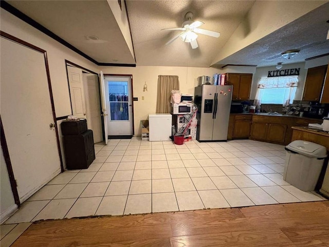 314 W Bordelon St, Gonzales, LA 70737 - kitchen featuring stainless steel fridge, dark countertops, light tile patterned floors, lofted ceiling, and ceiling fan