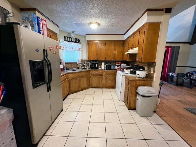 314 W Bordelon St, Gonzales, LA 70737 - kitchen featuring stainless steel refrigerator with ice dispenser, white electric range, brown cabinetry, under cabinet range hood, and decorative backsplash