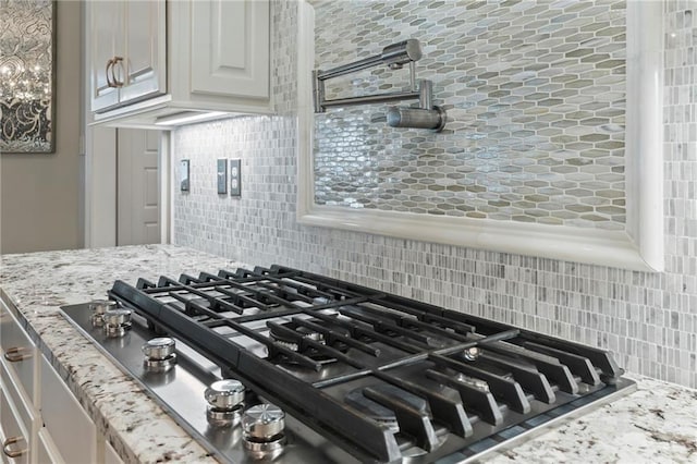 331 Memphis Trce, Covington, LA 70433 - kitchen view of stainless steel gas cooktop, backsplash, and light stone counters