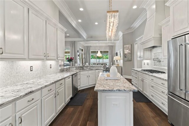 331 Memphis Trce, Covington, LA 70433 - kitchen with appliances with stainless steel finishes, crown molding, a peninsula, white cabinets, and dark wood-style flooring