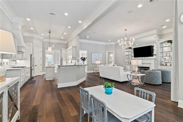 331 Memphis Trce, Covington, LA 70433 - dining room featuring a chandelier, recessed lighting, dark wood-type flooring, a fireplace, and baseboards