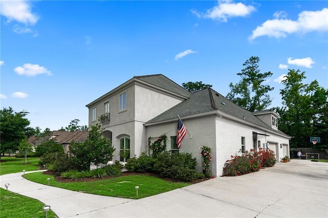 331 Memphis Trce, Covington, LA 70433 - view of home's exterior featuring a garage, a lawn, brick siding, and concrete driveway