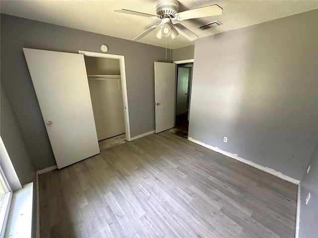2216 Teal St, Slidell, LA 70460 - unfurnished bedroom with wood finished floors, a textured ceiling, a closet, baseboards, and a ceiling fan