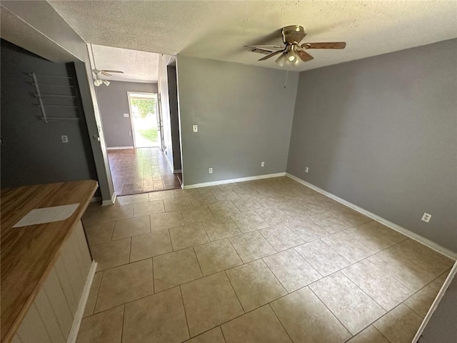 2216 Teal St, Slidell, LA 70460 - spare room with a textured ceiling, ceiling fan, tile patterned flooring, and baseboards