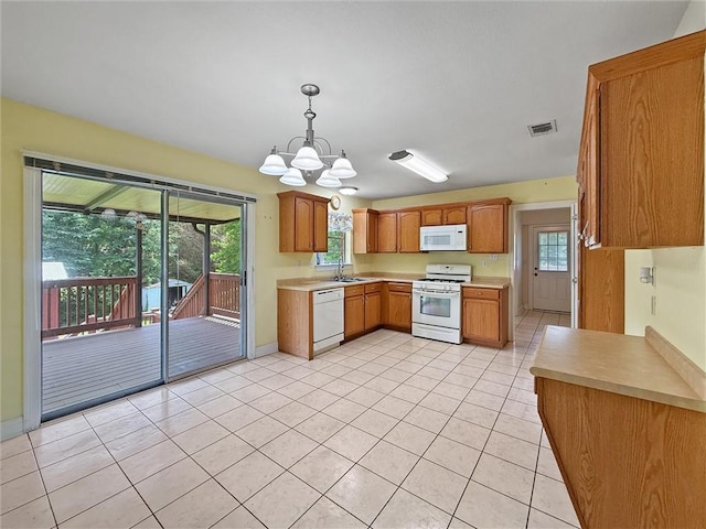 34159 Tupelo Ln, Slidell, LA 70460 - kitchen featuring white appliances, a sink, light countertops, a chandelier, and plenty of natural light