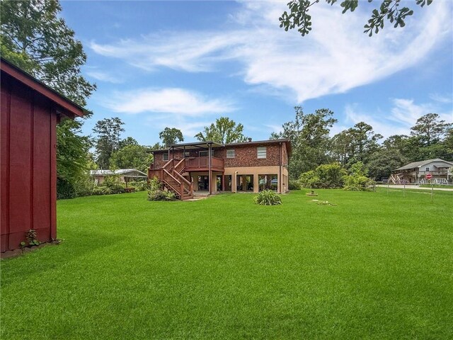 34159 Tupelo Ln, Slidell, LA 70460 - rear view of house featuring stairway, a deck, and a lawn