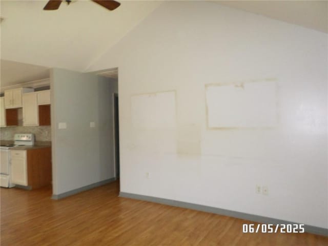 70305 I St, Covington, LA 70433 - unfurnished living room with ceiling fan, vaulted ceiling, light wood-style flooring, and baseboards