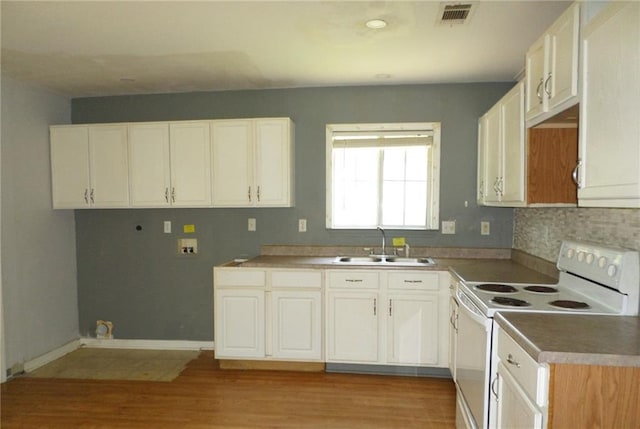 70305 I St, Covington, LA 70433 - kitchen with white range with electric stovetop, a sink, light wood finished floors, and white cabinetry