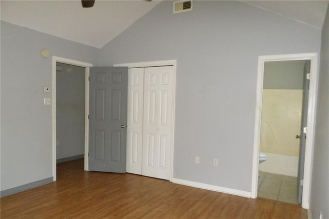 70305 I St, Covington, LA 70433 - unfurnished bedroom with lofted ceiling, a closet, wood finished floors, ensuite bath, and baseboards