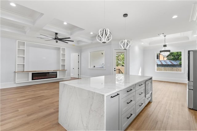8925 25th St, Metairie, LA 70003 - kitchen featuring recessed lighting, light wood-style flooring, ornamental molding, light stone countertops, and a center island