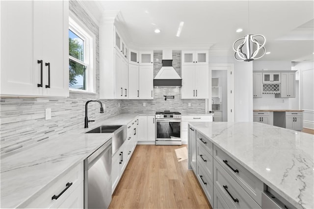 8925 25th St, Metairie, LA 70003 - kitchen featuring appliances with stainless steel finishes, premium range hood, a sink, backsplash, and glass insert cabinets