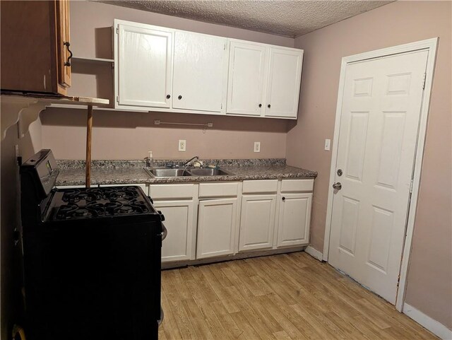 3127 Effie St, Slidell, LA 70458 - kitchen with gas stove, open shelves, light wood-style floors, white cabinets, and a textured ceiling