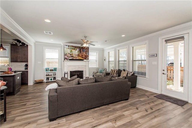2329 Bradbury Pl, Covington, LA 70433 - living area with ornamental molding, a fireplace, wood finished floors, ceiling fan, and recessed lighting