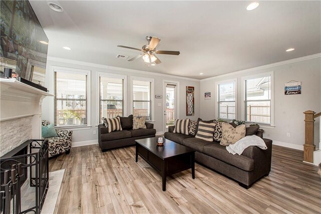 2329 Bradbury Pl, Covington, LA 70433 - living area with a stone fireplace, light wood-style flooring, ceiling fan, crown molding, and recessed lighting