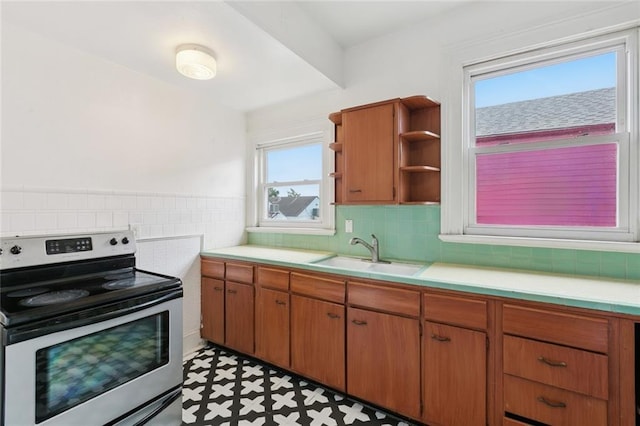 3141 Ponce De Leon St Unit 7, New Orleans, LA 70119 - kitchen with electric range, light countertops, light floors, and brown cabinetry