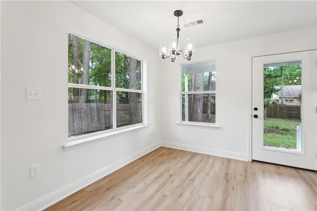 625 Woodridge Blvd, Mandeville, LA 70471 - unfurnished dining area with a chandelier, plenty of natural light, light wood finished floors, and baseboards