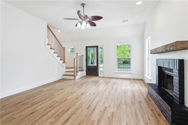 625 Woodridge Blvd, Mandeville, LA 70471 - unfurnished living room with light wood-style floors, stairs, baseboards, a fireplace, and a ceiling fan