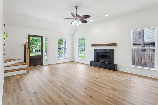625 Woodridge Blvd, Mandeville, LA 70471 - unfurnished living room with a brick fireplace, a ceiling fan, light wood-style flooring, stairway, and vaulted ceiling