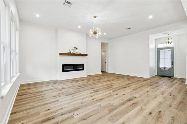 7211 Claiborne Ct, Arabi, LA 70032 - unfurnished living room with a chandelier, wood finished floors, a glass covered fireplace, and recessed lighting