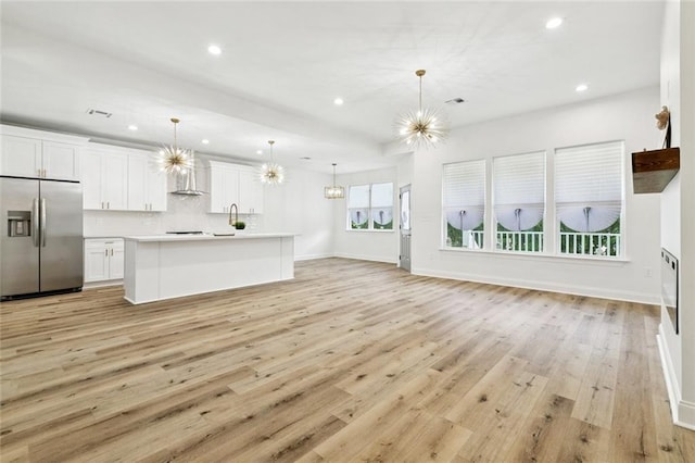 7211 Claiborne Ct, Arabi, LA 70032 - unfurnished living room featuring a chandelier, light wood-style floors, recessed lighting, baseboards, and a sink