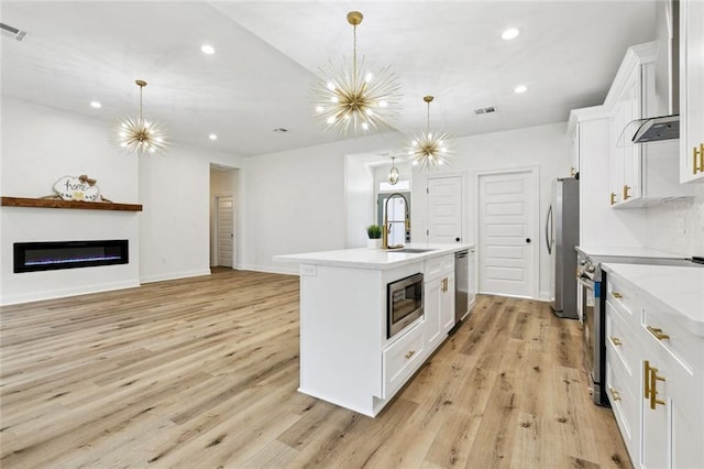 7211 Claiborne Ct, Arabi, LA 70032 - kitchen featuring stainless steel appliances, a center island with sink, recessed lighting, white cabinetry, and light wood-type flooring