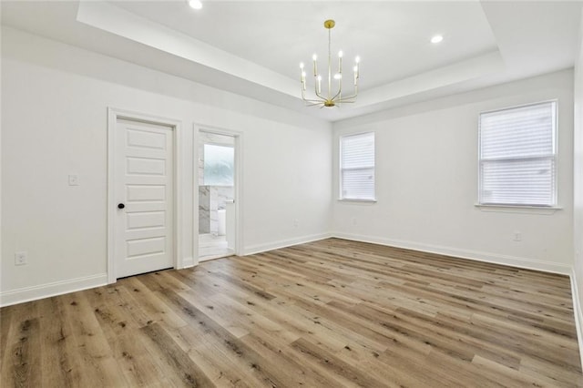 7211 Claiborne Ct, Arabi, LA 70032 - empty room with a raised ceiling, a chandelier, wood finished floors, healthy amount of natural light, and recessed lighting