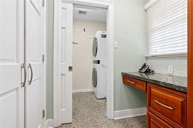 547 Jewel St, New Orleans, LA 70124 - laundry room with stacked washer and clothes dryer, baseboards, and a desk
