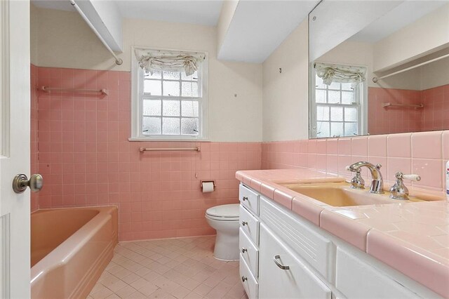 547 Jewel St, New Orleans, LA 70124 - bathroom with tile walls, tile patterned floors, vanity, toilet, and plenty of natural light