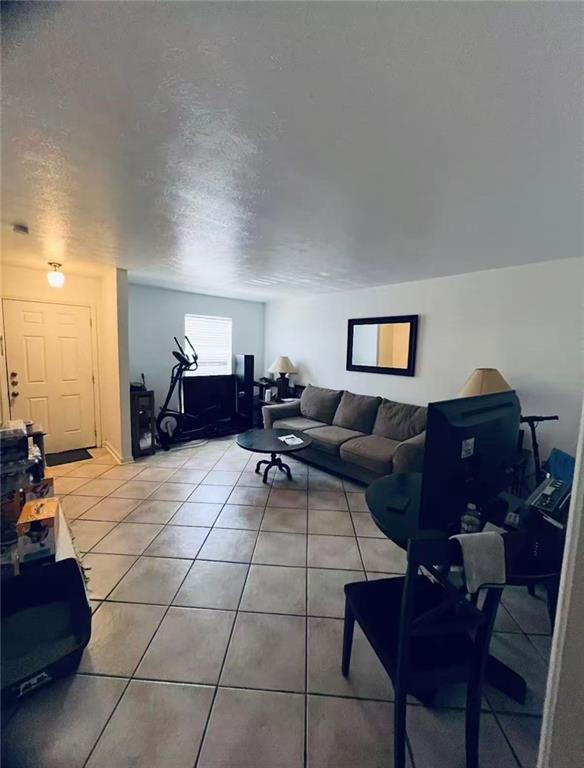 4401 Lefkoe St, Metairie, LA 70006 - living room with light tile patterned flooring and a textured ceiling