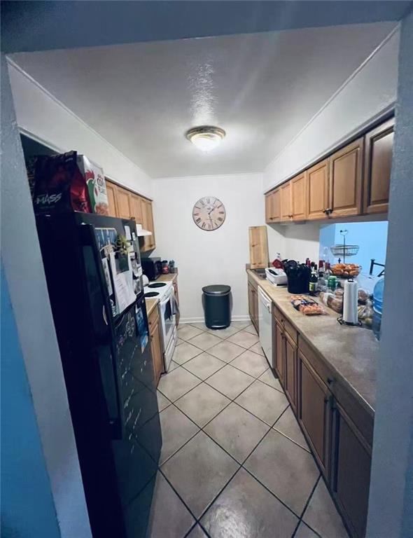 4401 Lefkoe St, Metairie, LA 70006 - kitchen featuring white appliances and light tile patterned floors