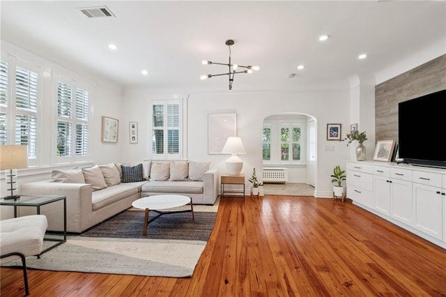 5930 Memphis St, New Orleans, LA 70124 - living area featuring arched walkways, a chandelier, light wood finished floors, baseboards, and recessed lighting