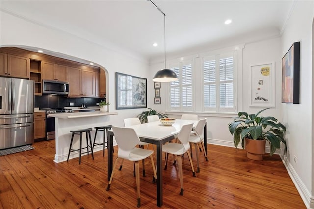 5930 Memphis St, New Orleans, LA 70124 - dining space with arched walkways, hardwood / wood-style flooring, recessed lighting, baseboards, and crown molding