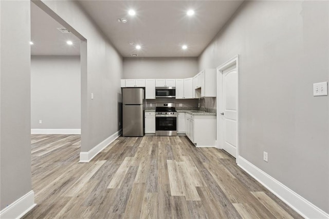 1400 Woodland Hwy, Belle Chasse, LA 70037 - kitchen featuring appliances with stainless steel finishes, light wood-style floors, white cabinets, baseboards, and recessed lighting
