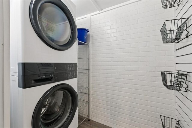 1400 Woodland Hwy, Belle Chasse, LA 70037 - laundry area with stacked washer / dryer, wood finished floors, and brick wall