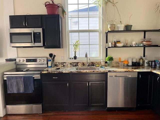 2754 Saint Ann St, New Orleans, LA 70119 - kitchen with stainless steel appliances, light stone countertops, open shelves, and dark wood-style flooring