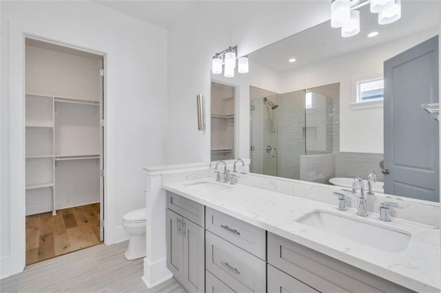 2509 Palmyra St, New Orleans, LA 70119 - full bathroom featuring a stall shower, a spacious closet, double vanity, wood finished floors, and recessed lighting