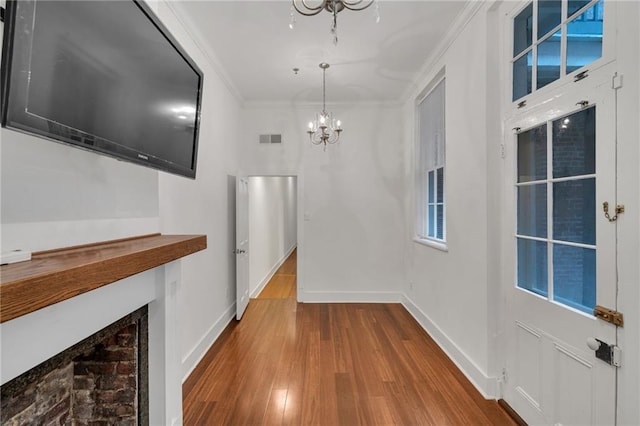 526 Madison St Unit 1B, New Orleans, LA 70116 - unfurnished dining area featuring a chandelier, wood finished floors, and crown molding