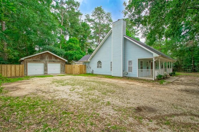 70380 K St, Covington, LA 70433 - view of side of property featuring a chimney, a detached garage, and a porch