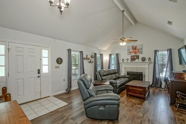 70380 K St, Covington, LA 70433 - living area featuring beamed ceiling, wood finished floors, a tile fireplace, ceiling fan, and a chandelier