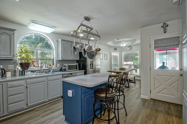 70380 K St, Covington, LA 70433 - kitchen with stainless steel appliances, light countertops, a center island, a breakfast bar area, and plenty of natural light