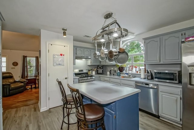 70380 K St, Covington, LA 70433 - kitchen with stainless steel appliances, light wood-type flooring, light countertops, and under cabinet range hood