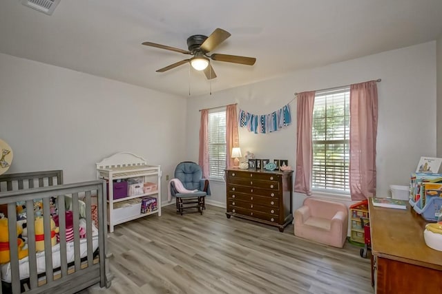 70380 K St, Covington, LA 70433 - bedroom featuring wood finished floors, a crib, and a ceiling fan