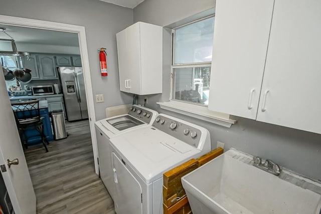 70380 K St, Covington, LA 70433 - laundry area with separate washer and dryer, cabinet space, and wood finished floors